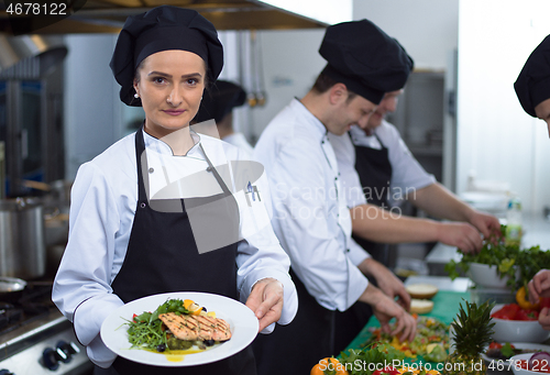 Image of Chef holding dish of fried Salmon fish fillet