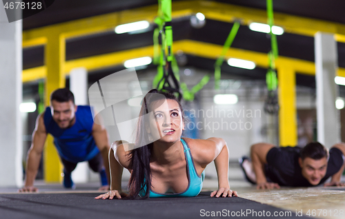 Image of young healthy people doing pushups