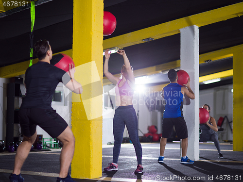 Image of young athletes working out with medical ball