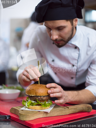 Image of chef finishing burger