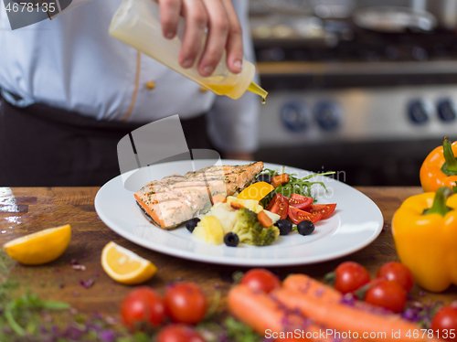 Image of Chef finishing steak meat plate