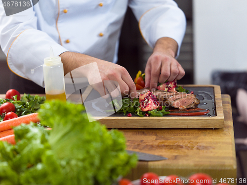 Image of closeup of Chef hands serving beef steak