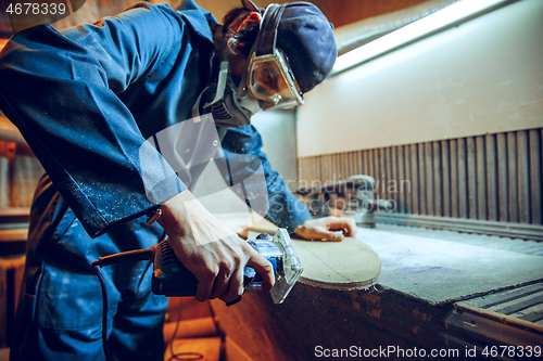 Image of Carpenter using circular saw for cutting wooden boards.