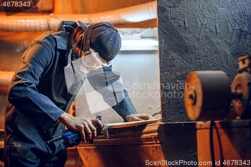 Image of Carpenter using circular saw for cutting wooden boards.