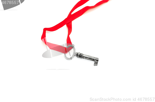 Image of Vintage silver key with red ribbon on white background