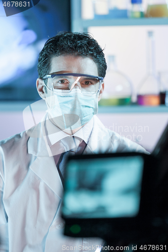 Image of Laboratory hospital clinic doctor, scientist or exper, wearing protacive mask while addressing public in media interview explaining preventive measures against corona virus pandemic outbreak