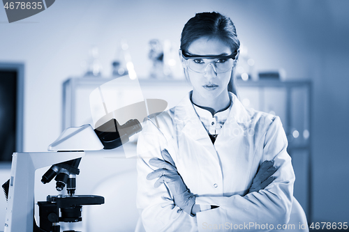 Image of Portrait of a attractive, young, confident female health care professional in hes working environment. Blue toned black and white image