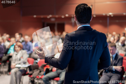 Image of Public speaker giving talk at business event.