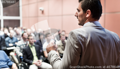 Image of Public speaker giving talk at business event.