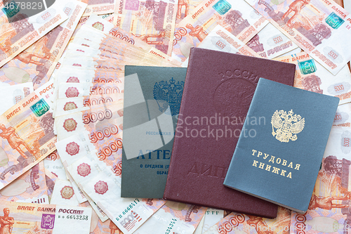 Image of A certificate, a red diploma and a work book are on the five thousandth Russian rubles