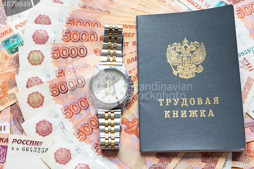 Image of On a pack of five thousandth bills there is a work book and a watch