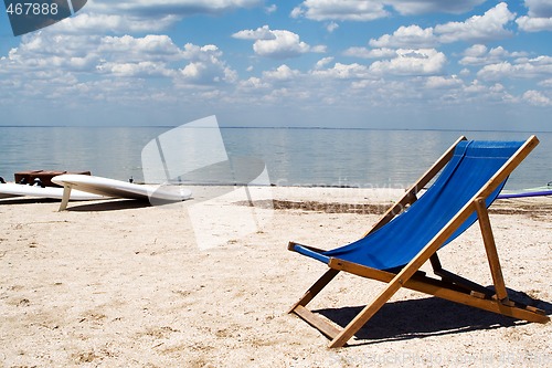 Image of Chair on a beach against a gulf and clouds