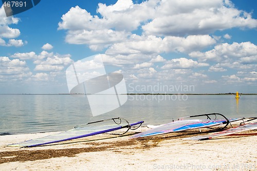 Image of Surfboards on a beach a sea bay on background of the blue sky an