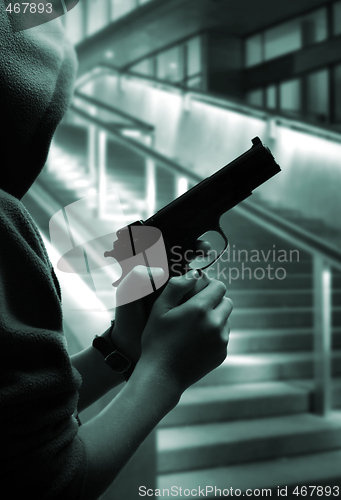 Image of Boy with a gun at street at night