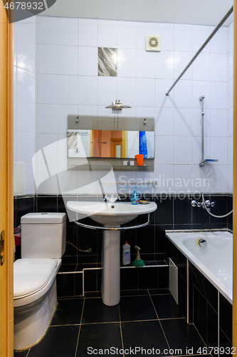 Image of General view of a classic bathroom interior in an apartment, with black and white tiles