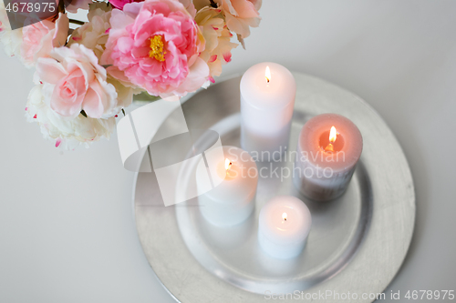 Image of candles burning on table and flowers at cozy home