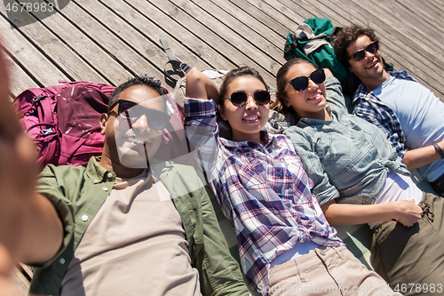 Image of friends or tourists with backpacks taking selfie