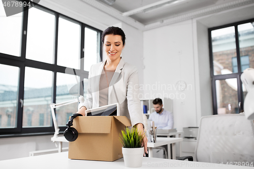 Image of happy businesswoman with personal stuff at office