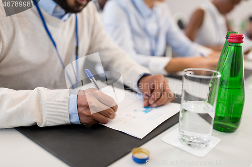 Image of businessman with papers at business conference