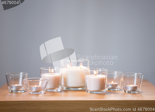 Image of burning white fragrance candles on wooden table