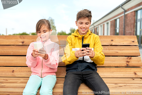 Image of children with smartphones sitting on street bench