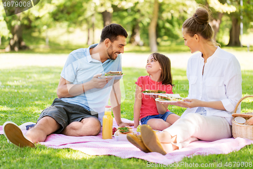 Image of happy family having picnic at summer park