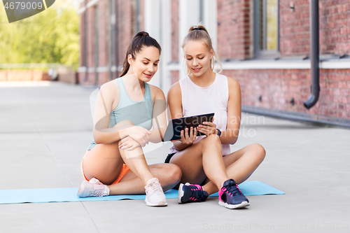 Image of sporty women or friends with tablet pc on rooftop