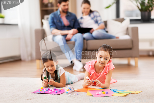 Image of happy sisters doing arts and crafts at home