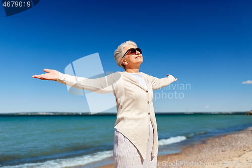 Image of portrait of senior woman in sunglasses on beach