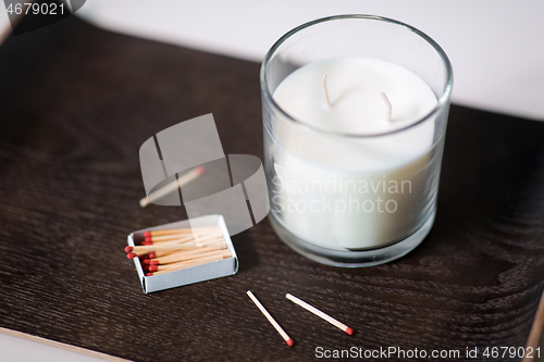 Image of fragrance candle and matches on tray on table