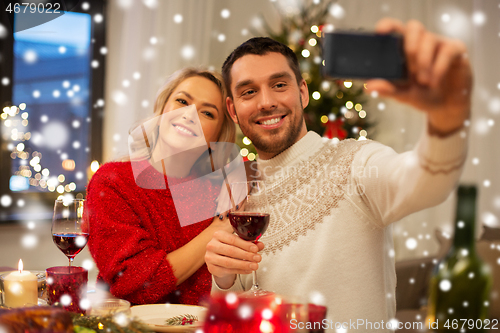 Image of happy couple taking selfie at christmas dinner