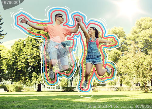 Image of happy teenage couple jumping at summer park