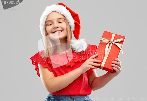 Image of pleased girl in snata hat with christmas gift