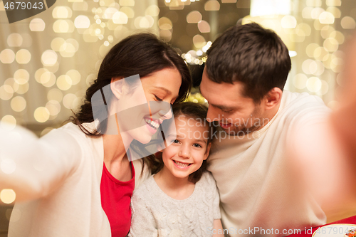 Image of happy family taking selfie at christmas