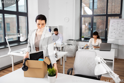 Image of female office worker with box of personal stuff