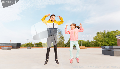 Image of happy children jumping on roof and showing peace