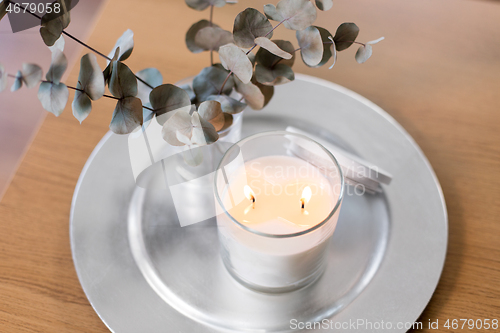 Image of burning white candles on table at cozy home