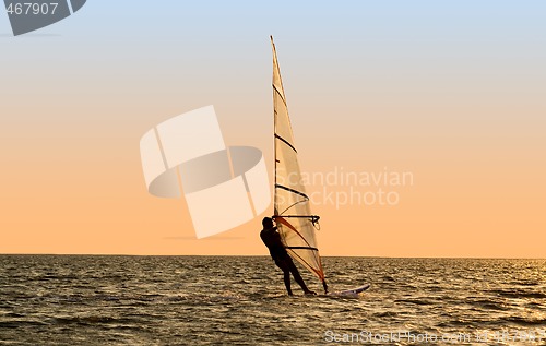 Image of Silhouette of a windsurfer on waves of a gulf 