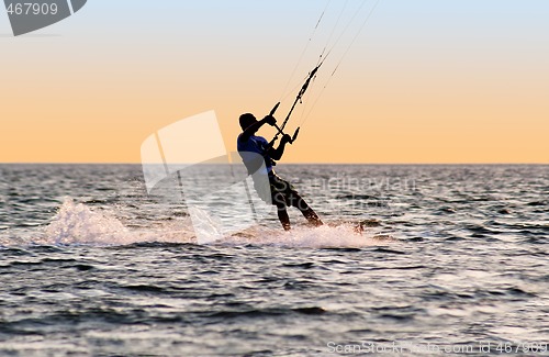 Image of Silhouette of a kitesurfer on waves of a gulf 