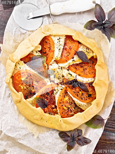 Image of Galeta with tomato and cheese on wooden board top