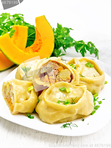 Image of Manty with meat and pumpkin in plate on light wooden board