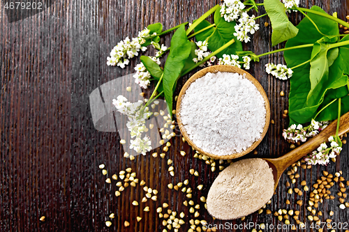 Image of Flour buckwheat green in bowl with flowers on dark board top