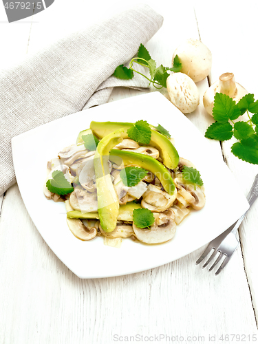 Image of Salad of avocado and champignons on light wooden board