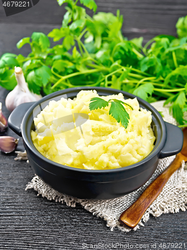 Image of Potatoes mashed in saucepan on wooden board