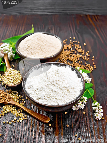 Image of Flour buckwheat green and brown in bowls with flowers on wooden 