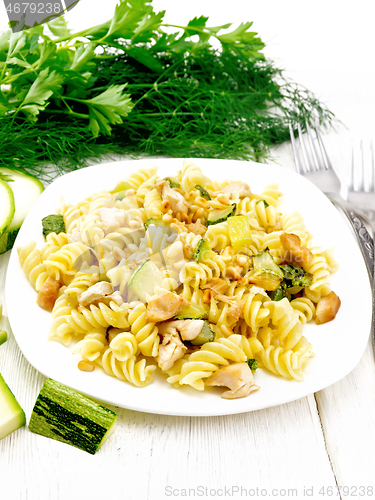 Image of Fusilli with chicken and zucchini in plate on light board