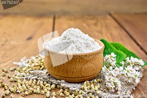 Image of Flour buckwheat green in bowl with flowers on old wooden board