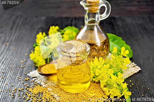 Image of Oil mustard in jar and decanter with flower on board
