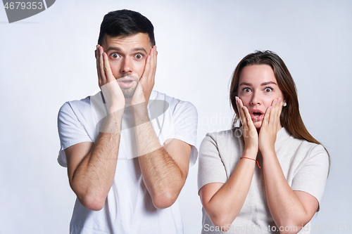 Image of couple confused scary emotion over gray background