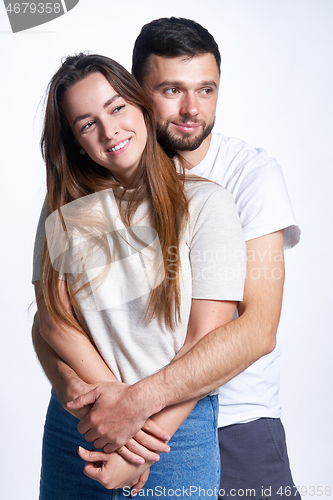 Image of Smiling young couple hugging, studio portrait over light background